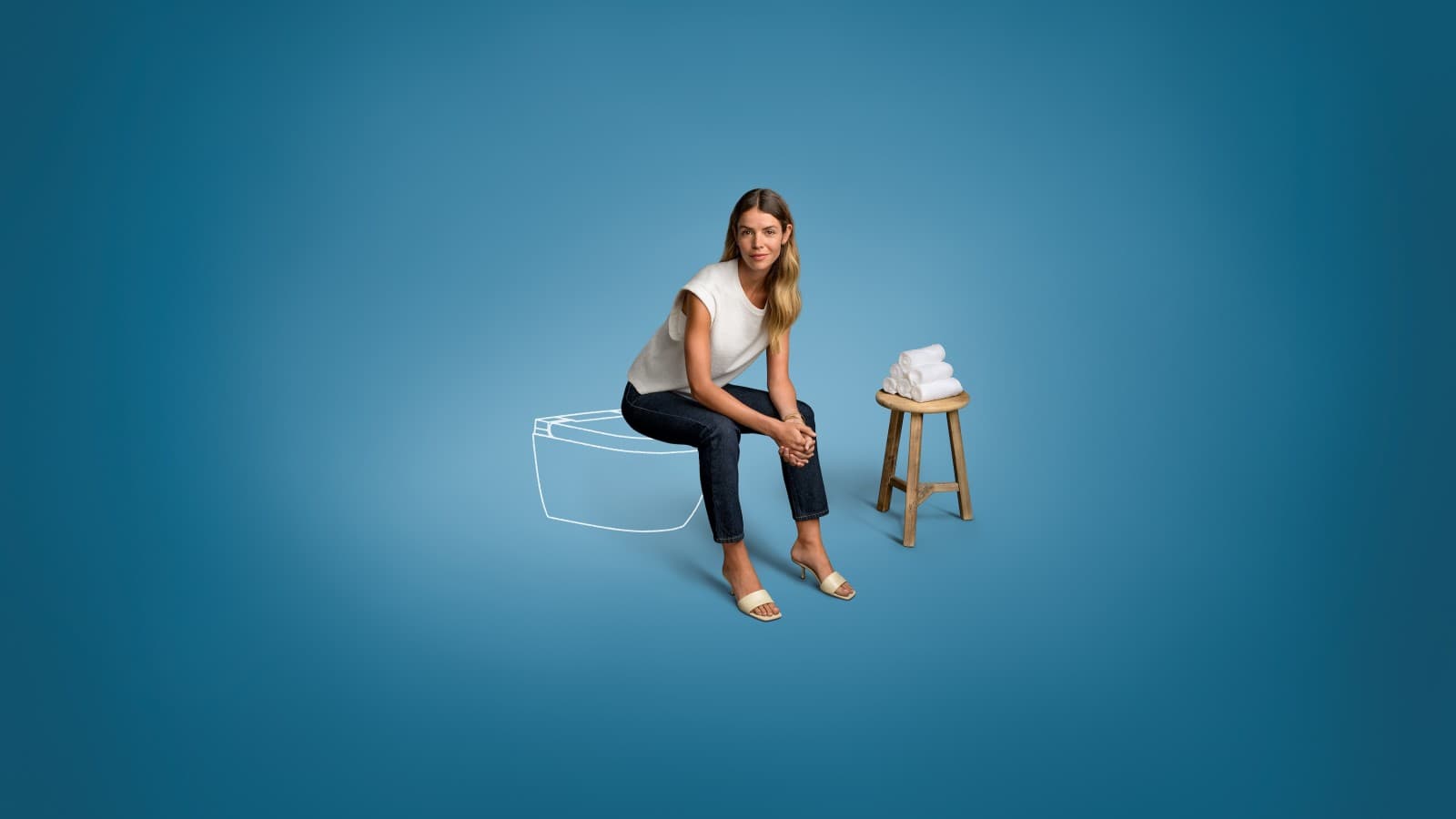 Amy sedí na sprchovací toaletě Geberit AquaClean Alba. Amy sedí na sprchovací toaletě Geberit AquaClean Alba.